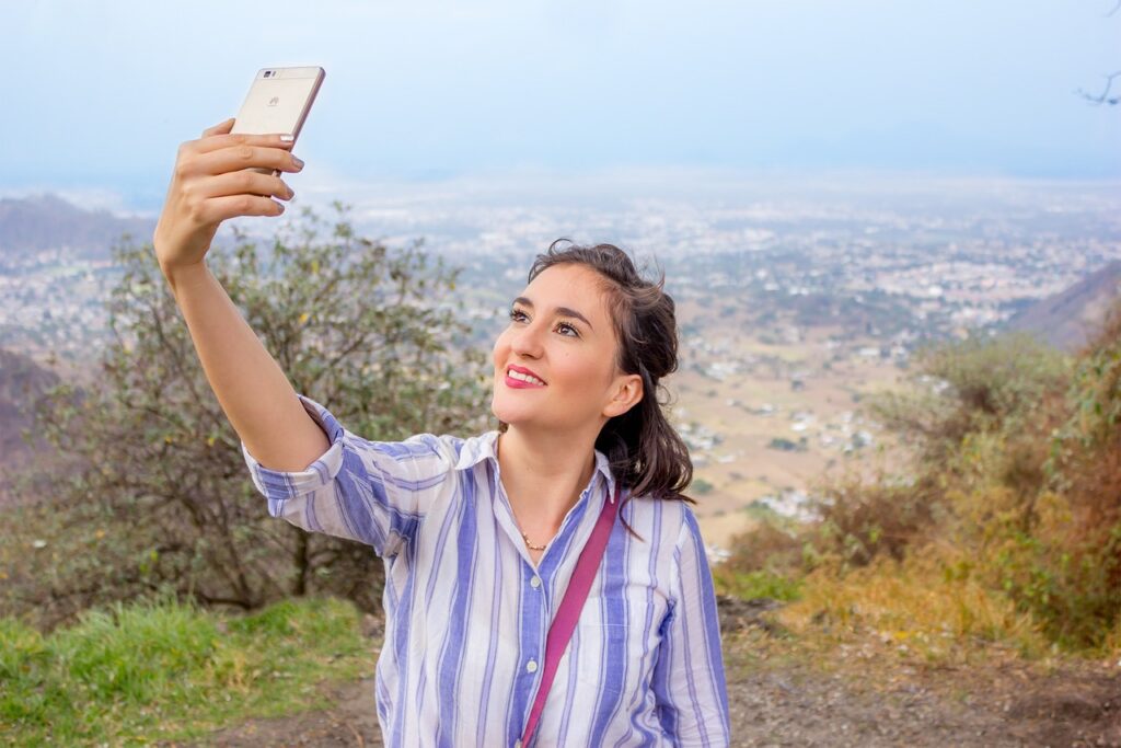 Chica con móvil en las manos que se está fotografiando.